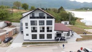 ProzorにあるPerla jezera B&Bの白い建物を上空から撮影した写真。建物の外には人々が立っている。 +34枚の写真