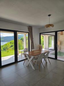 a dining room with a table and chairs and windows at Moon Lake Bicaz - Aurora Garden in Buhalniţa