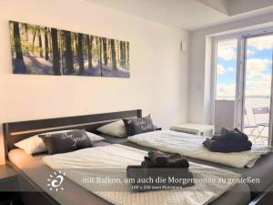 two beds in a room with a window at Penthouse de Ool Blick auf das Wattenmeer in Neufeld