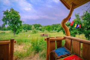 a porch with a bench with a view of a field at Walnussnest - Tiny House im Grünen in Bäbelin