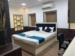 a bedroom with a bed with a desk and a chair at Hotel O The Diamond Palace in Kolkata