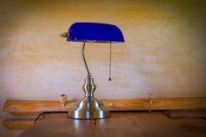 a blue lamp sitting on top of a wooden table at Walnussnest - Tiny House im Grünen in Bäbelin