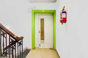 a green and white door with a fire hydrant on the wall at Hotel O The Diamond Palace in Kolkata
