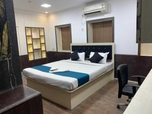 a bedroom with a bed with a chair and a desk at Hotel O The Diamond Palace in Kolkata
