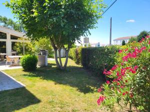 a garden with pink flowers and a tree at Maison venitia t5 in Aussonne