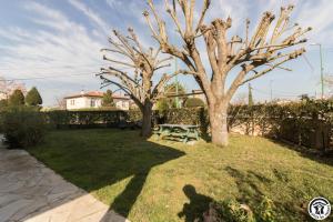 a yard with two trees and a picnic table at Maison venitia t5 in Aussonne
