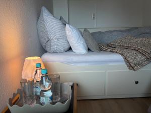 a bed with pillows and a nightstand next to a table with a lamp at Dorfblick Barweiler in Barweiler