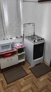 a small kitchen with a stove and a microwave at Cantinho aconchegante in Timbó