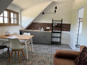 a kitchen and living room with a table and chairs at Siedlisko Marianna, apartamenty Janowiec, Kazimierz Dolny in Ławecko