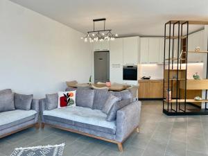 a living room with two couches and a kitchen at SunkissedVilla in Draç