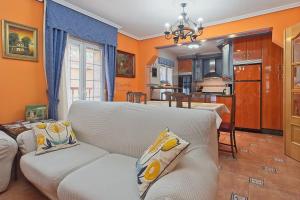 a living room with a white couch and a kitchen at La Cuadra in Cabornera