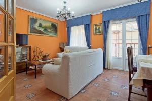 a living room with orange walls and a white couch at La Cuadra in Cabornera