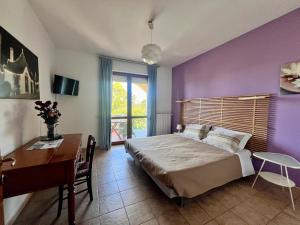 a bedroom with purple walls and a desk and a bed at B&B La Rosa Blu in Bari +128 photos