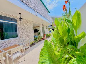a patio of a house with a bench and plants at Serene Dhigurah in Dhigurah