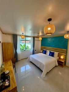 a bedroom with a white bed and a blue wall at Serene Dhigurah in Dhigurah +36 photos