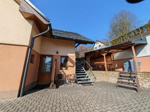 a house with a patio and stairs to the backdoor at Apartmány 3J in Trutnov