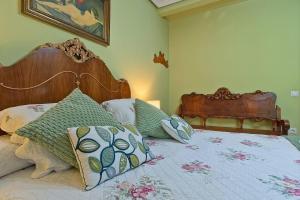 a bedroom with a bed with a wooden headboard and pillows at La Cuadra in Cabornera