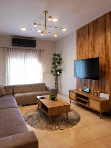 a living room with a couch and a flat screen tv at Asul Seaside Retreat in Stavros