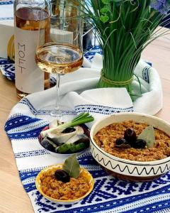 a table with a bowl of food and a glass of wine at Pensiunea Prigoria in Murighiol