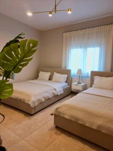 a bedroom with two beds and a window at Asul Seaside Retreat in Stavros +20 photos
