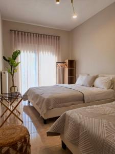 a bedroom with two beds and a window at Asul Seaside Retreat in Stavros