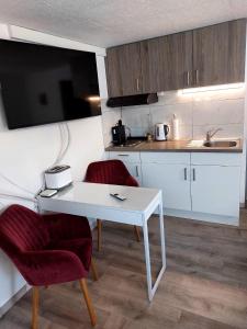 a kitchen with a white table and two chairs at Viktoria's B&B in Unterkulm