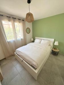 a large white bed in a room with green walls at Cala Serena Saint Cyprien in Lecci +10 photos