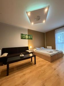 a bedroom with a bed and a couch and a table at Casa Victoria in Pécs