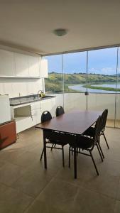 a table and chairs in a room with a large window at Lagamar Hotel Varginha in Varginha