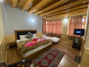 a bedroom with a bed and a television in it at Zaltak Guest House and Hostel in Leh