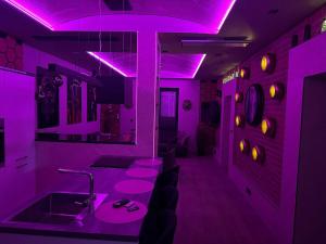 a purple room with a bar with chairs and a sink at Ambiente Apartment in Olfen +29 photos