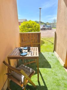 a table and chairs on a patio with grass at Cala Serena Saint Cyprien in Lecci