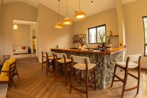 a bar with chairs and a counter in a room at Huduma Bwindi Lodge in Kisoro