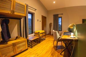 a living room with a desk and a table with chairs at Huduma Bwindi Lodge in Kisoro