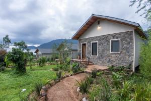 a home with a stone house with a garden at Huduma Bwindi Lodge in Kisoro