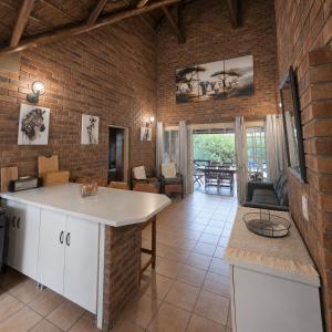a kitchen and living room with a brick wall at Dumela Afrika in Marloth Park