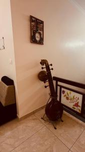 a guitar in a room with a clock on the wall at Arackal in Trivandrum +9 photos