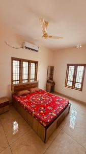 a bedroom with a large bed in a room with windows at Arackal in Trivandrum