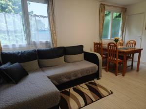 a living room with a couch and a table at Erdőszéli vendégház in Dudar