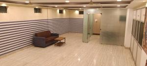 a waiting room with a chair and a glass door at Vybhav Residency in Anantapur
