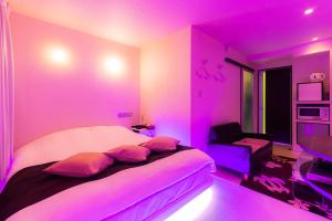 a bedroom with a purple room with a bed and a chair at ホテルR-Adult only-lovehotel in Gotemba