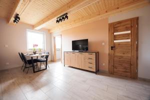 a dining room with a table and a tv and a door at Agroturystyka Oliweczka 31 in Potok Wielki
