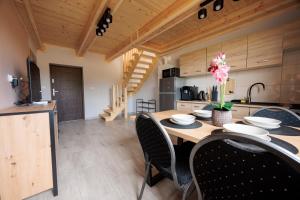 a kitchen and dining room with a wooden table and chairs at Agroturystyka Oliweczka 31 in Potok Wielki