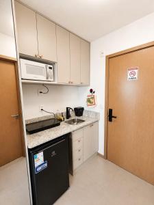 a small kitchen with a sink and a microwave at VISTA MAR SPOT Barra in Salvador