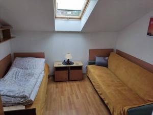 a small bedroom with a bed and a couch at Olimpia Pobierowo in Pobierowo