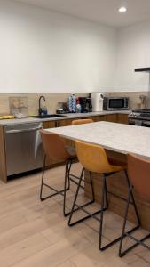 a kitchen with a table and chairs in a kitchen at Soho House - 20 Min to NYC - Breakfast Included- A in Jersey City