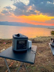 a toaster sitting on a table next to the water at lodi campers rental in Theth