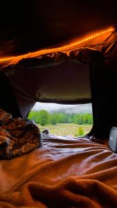 a bed in the back of a tent with lights at lodi campers rental in Theth