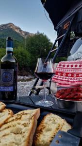 a glass of wine and bread and a bottle of wine at lodi campers rental in Theth