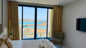 a bedroom with a large window with a view of the ocean at Vista Mar Suites in Praia
